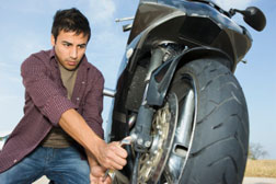 Young man changing motorcycle tire